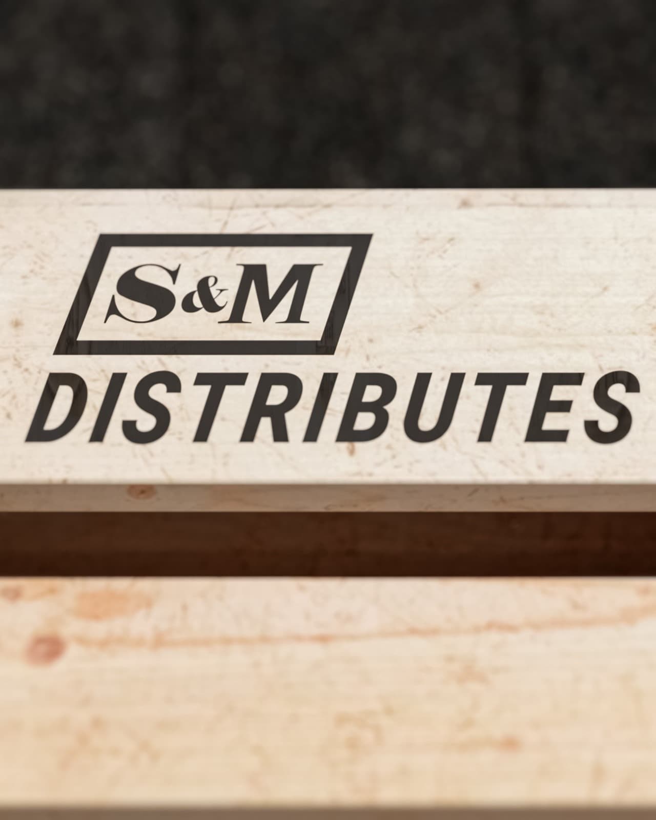 The S&M Distributes logo displayed on a wooden pallet