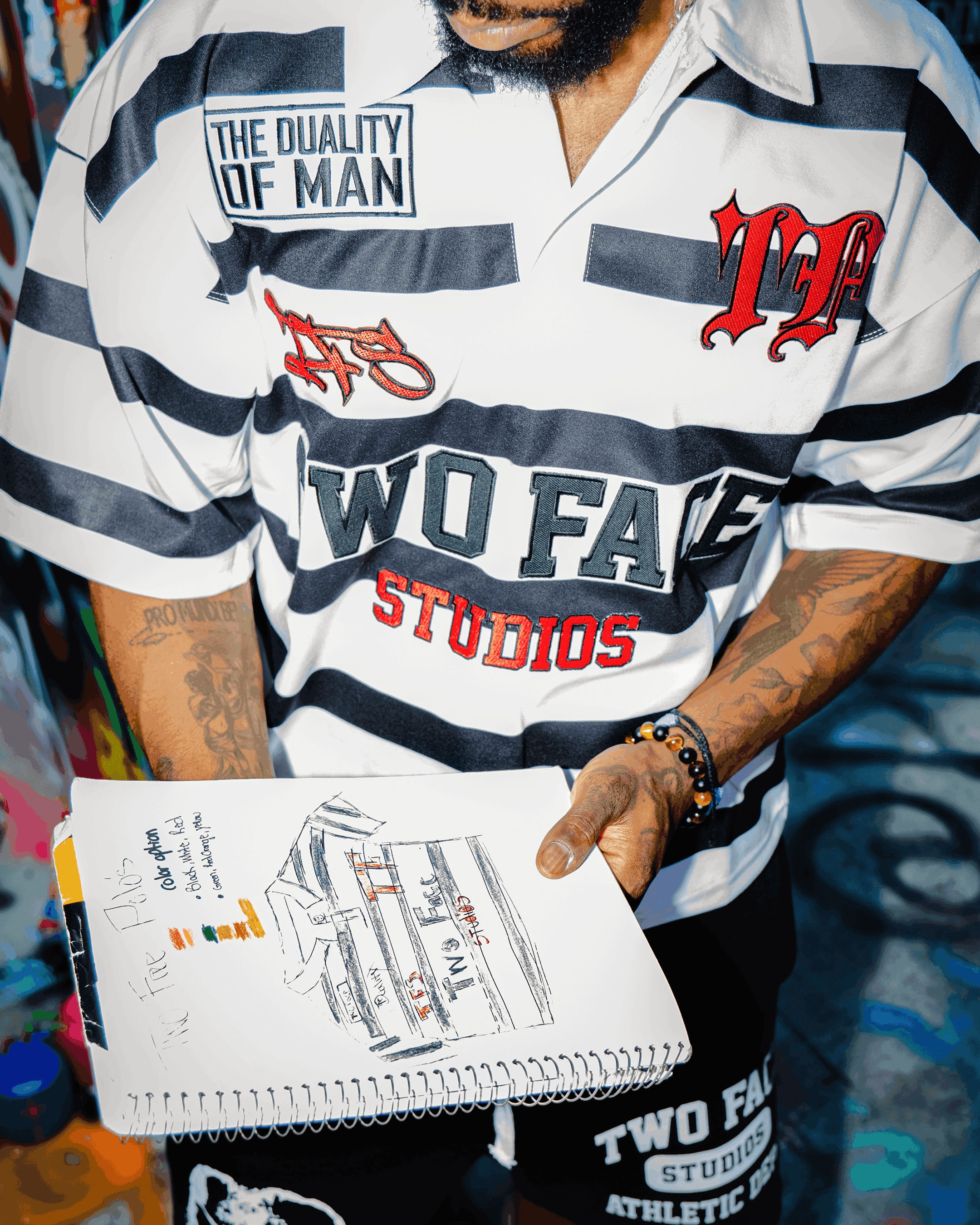 A sketchbook showing the process with a model wearing the TwoFace Studios rugby polo